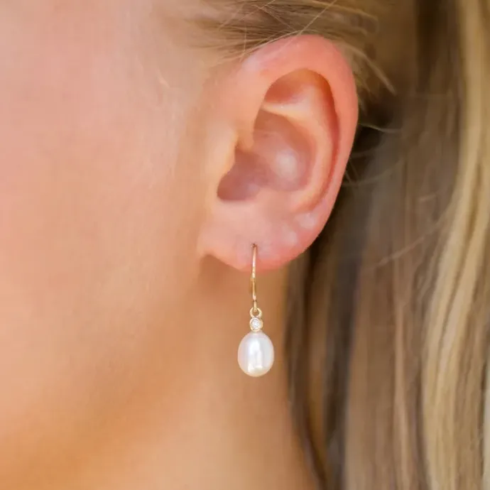 Ovale 7 - 8 mm aaa-graded ferskvandsperle brillantøreringe i 14 karat guld med diamanter
